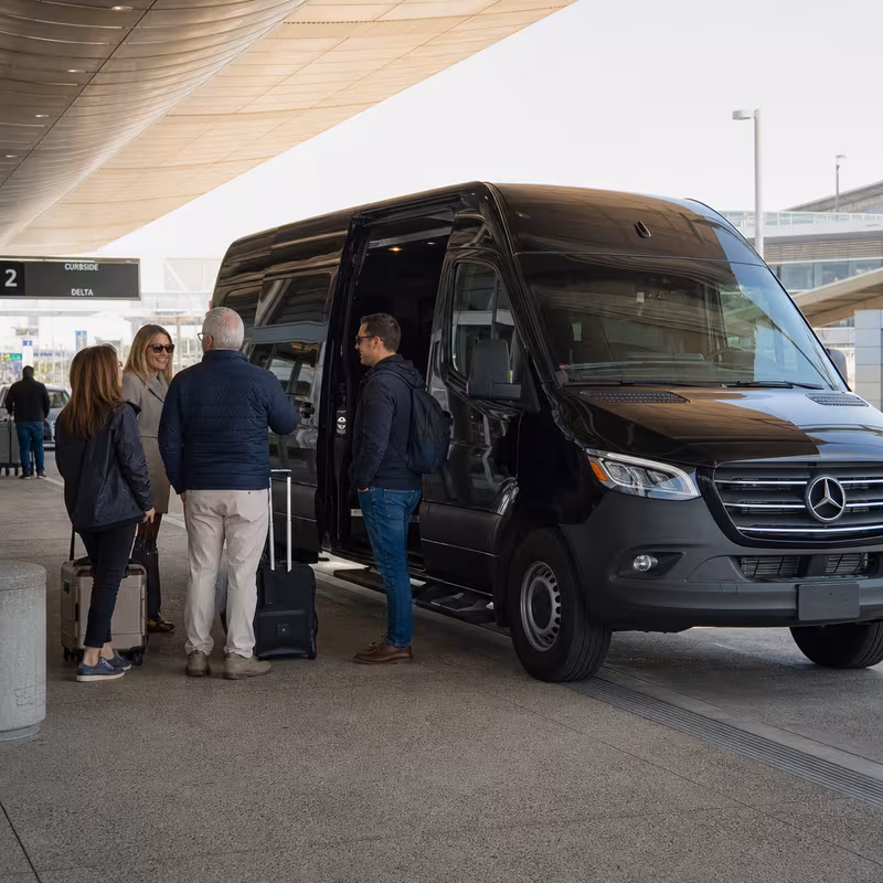 Group boarding a white charter bus for Airport Transportation transportation in San Diego