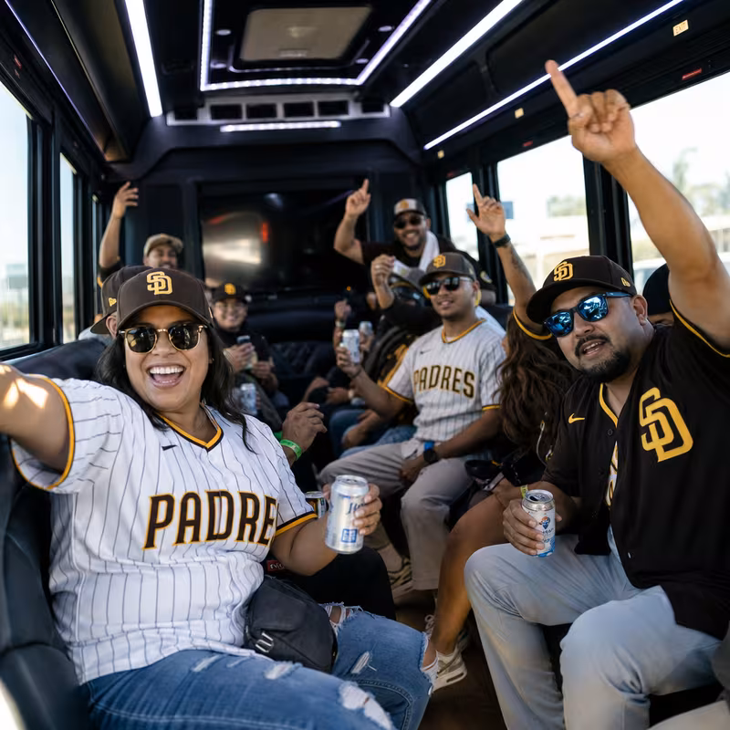 Group boarding a white charter bus for Sporting Event Transportation transportation in San Diego